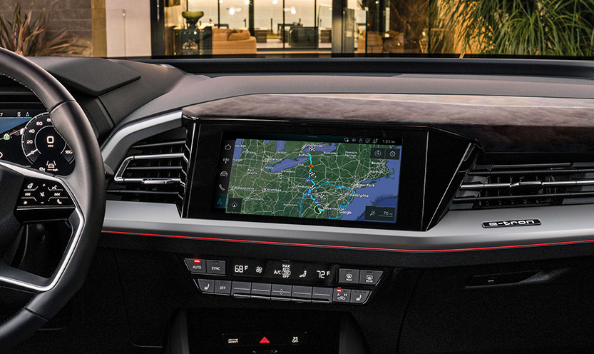 Vue intérieure d'une cabine Audi, montrant la fonction de planificateur de trajet intégré sur l'écran MMI.