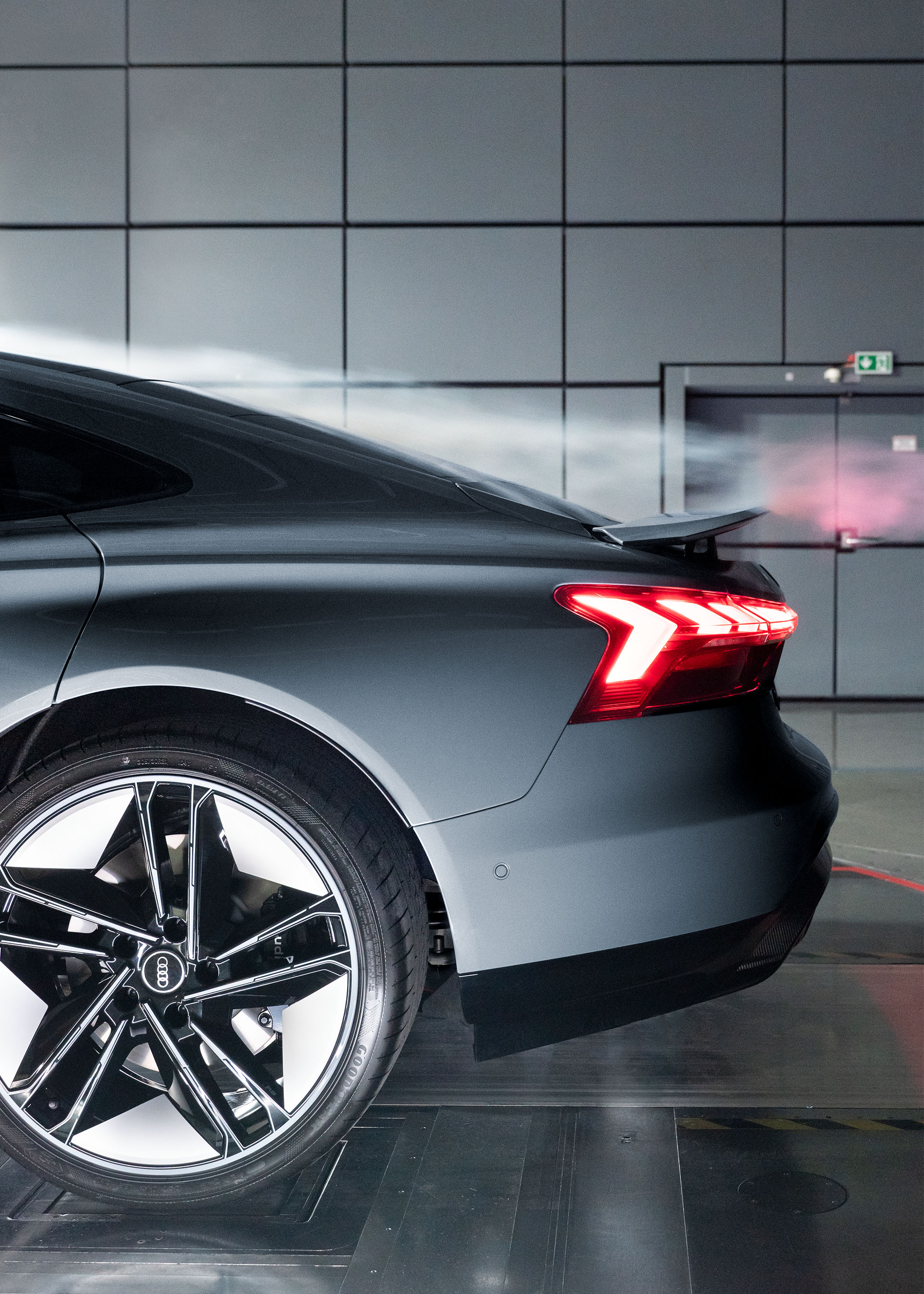 Profil latéral de l’aileron arrière d’une Audi RS e-tron GT, pendant qu’un canon à fumée montre l’écoulement d’air au-dessus.